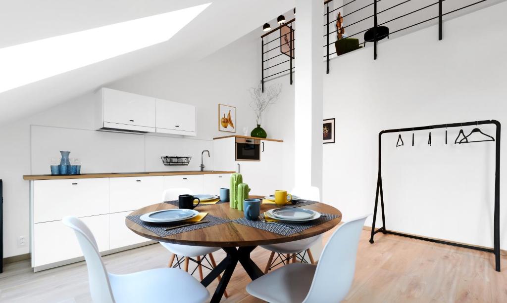 a kitchen and dining room with a wooden table and chairs at HONEST Smichov in Prague