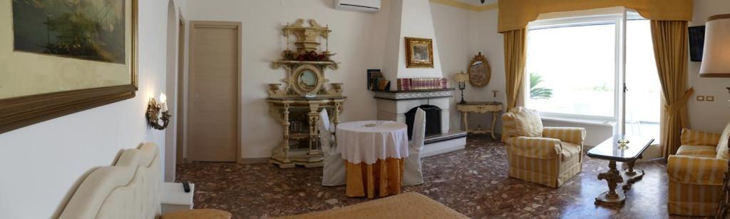 a living room with a fireplace and a clock in a room at Appartamento in villa ad Ischia in Ischia