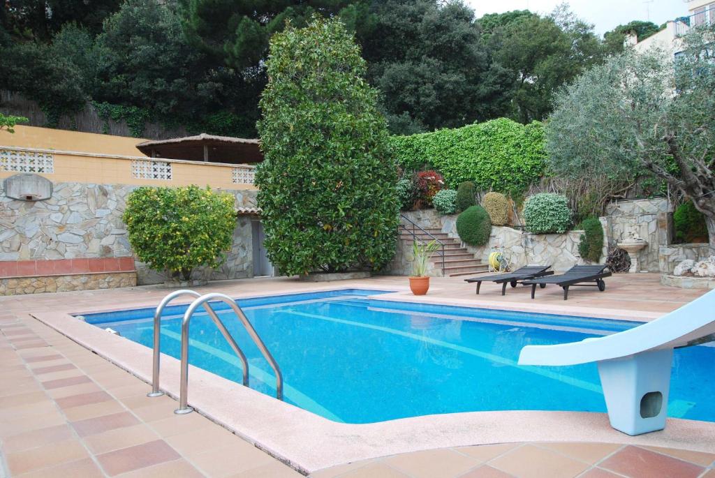 a swimming pool in a yard with a house at Villa Magnolia in Mataró