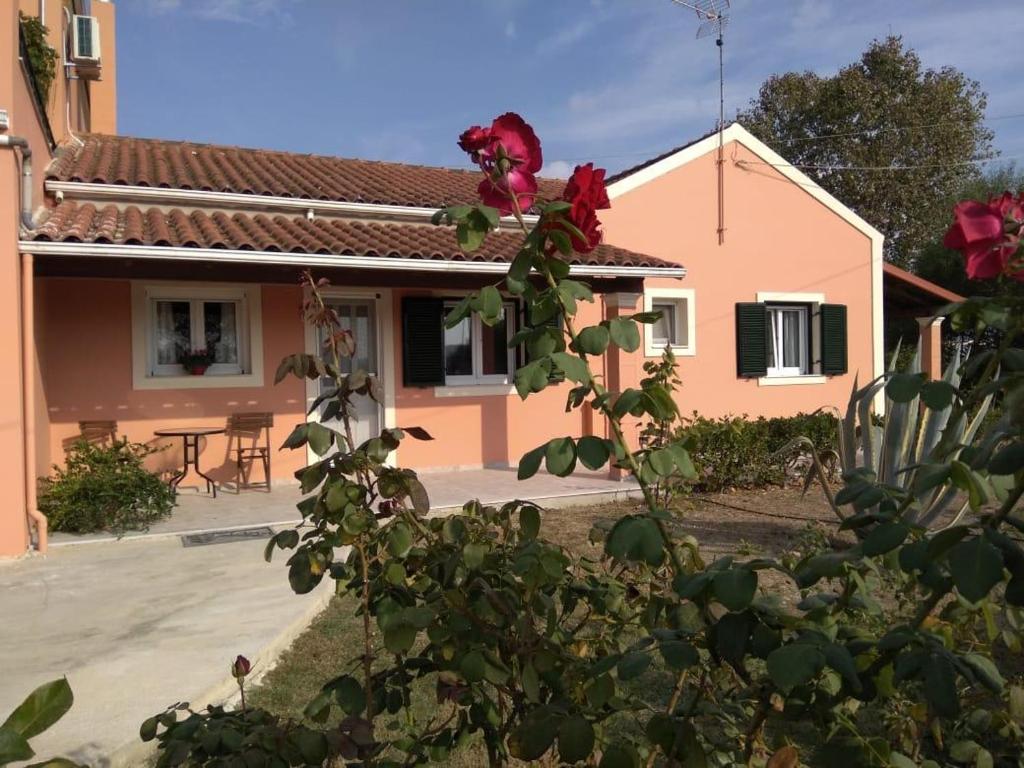 a house with a red rose on the side of it at Lonelia's Family Homes in Lefkímmi