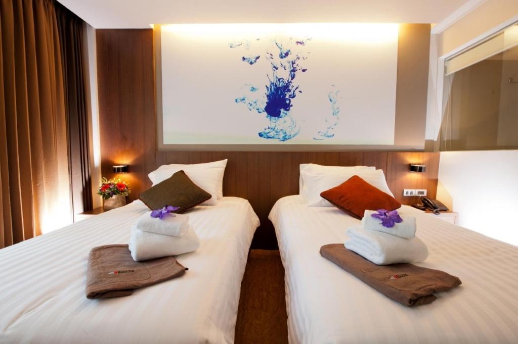 Dos camas en una habitación de hotel con toallas. en 41 Suite Bangkok, en Bangkok
