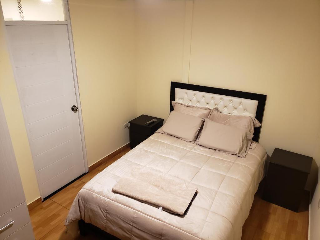een slaapkamer met een bed met witte lakens en kussens bij CASA DE TURISTAS AREQUIPA in Arequipa