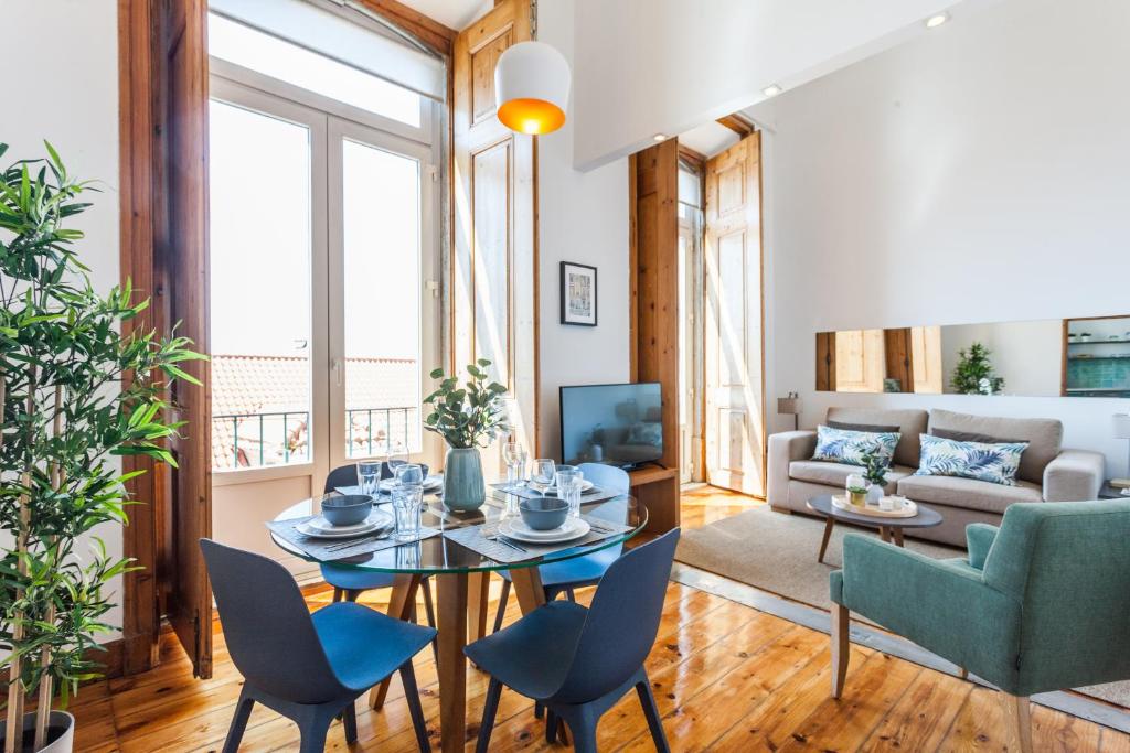 een woonkamer met een tafel en stoelen en een bank bij FLH Alfama River View Flat in Lissabon