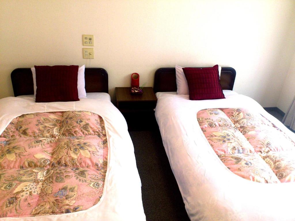 Postel nebo postele na pokoji v ubytování Tenjin Lodge