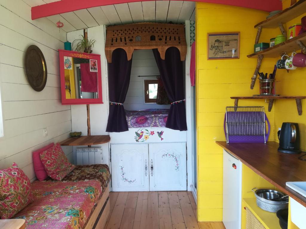 een tiny house met een keuken en een woonkamer bij Roulotte coin de nature in Lannion