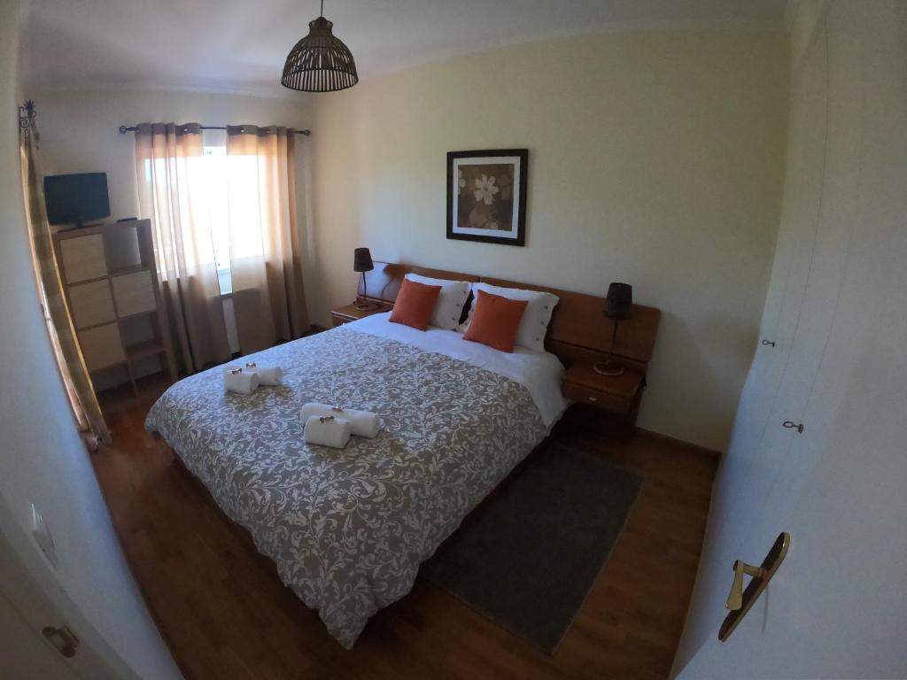 a bedroom with a bed with two candles on it at Golf & Beach Apartment in Charneca