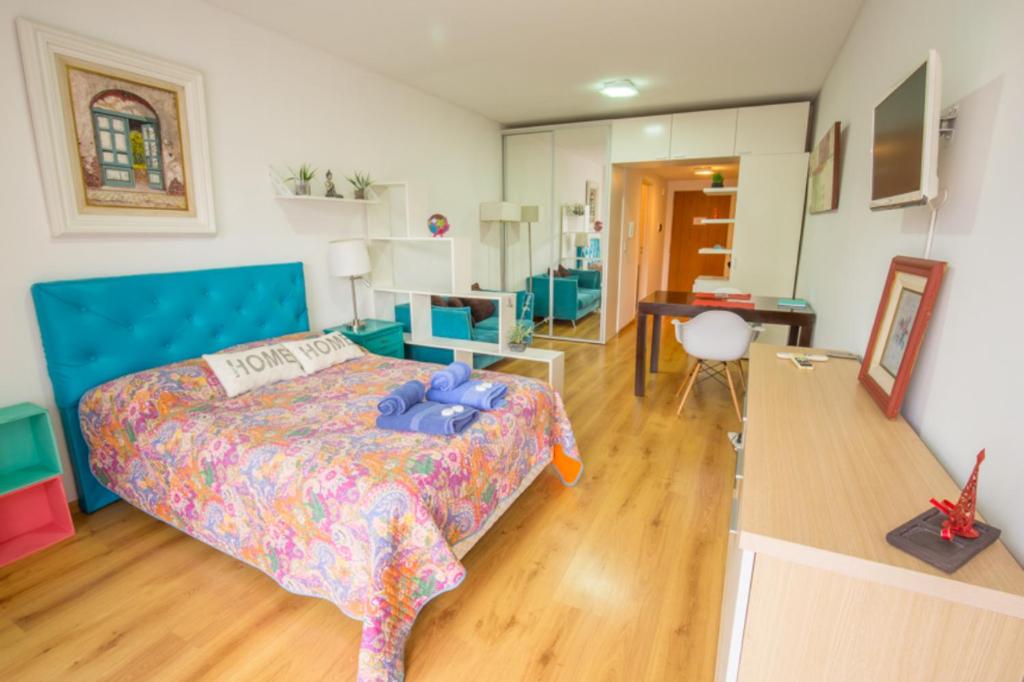 1 dormitorio con 1 cama con cabecero azul en Cómodo Departamento en el Centro en Buenos Aires
