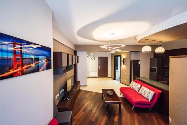 a living room with a red couch and a living room with at Parliament on Rustaveli Studio in Tbilisi City