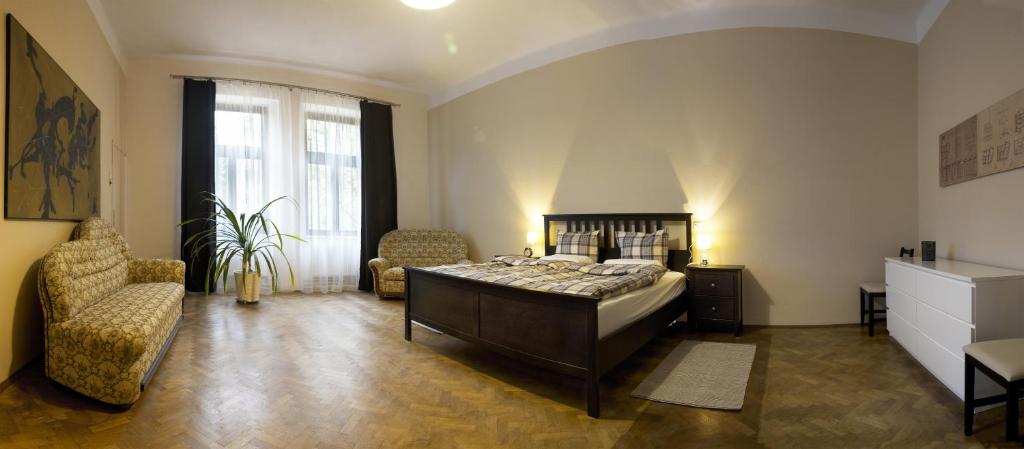 a bedroom with a bed and two chairs in it at Apartmán pod rozhlednou in Roudnice nad Labem