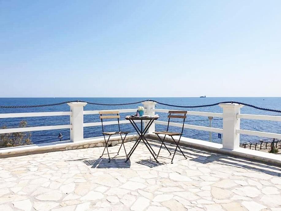 einen Tisch und Stühle auf einer Terrasse mit Meerblick in der Unterkunft Casa Viky in Bari Palese