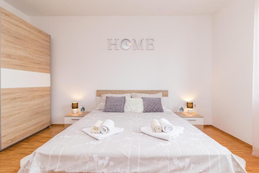 - une chambre avec un grand lit blanc et 2 serviettes dans l'établissement Apartments Rede, à Pula