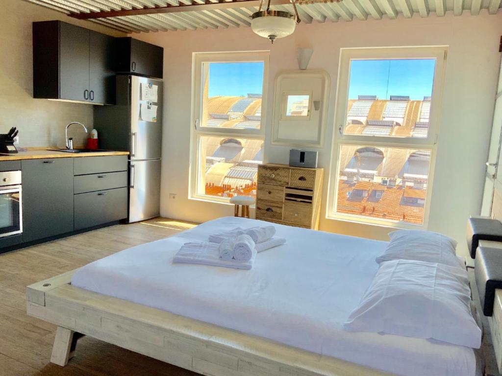 un grande letto in una cucina con due finestre di LUXURY STUDIO UNIQUE VIEW NEAR MAIN STATION a Milano