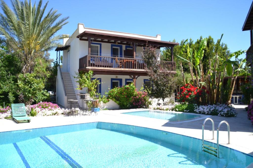 a house with a swimming pool in front of a house at Paradise Gümüşlük in Gümüşlük