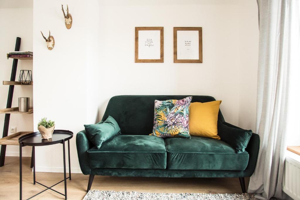 a green couch in a living room with a table at Fewo-TS / Das Loft zum Wohlfühlen in Traunstein