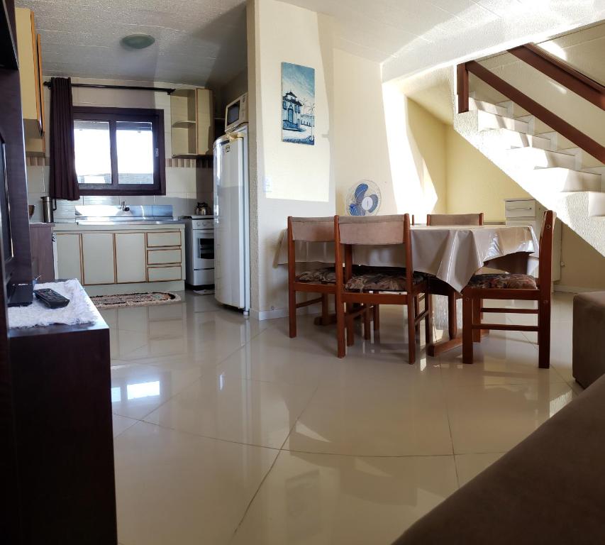 una cucina e una sala da pranzo con tavolo e sedie di Residencial Hannah - Casa 6 - Porto Belo SC - Bairro Perequê a Porto Belo