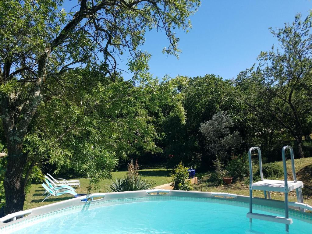a swimming pool with a chair in a yard at Entre Nîmes et Arles in Bellegarde