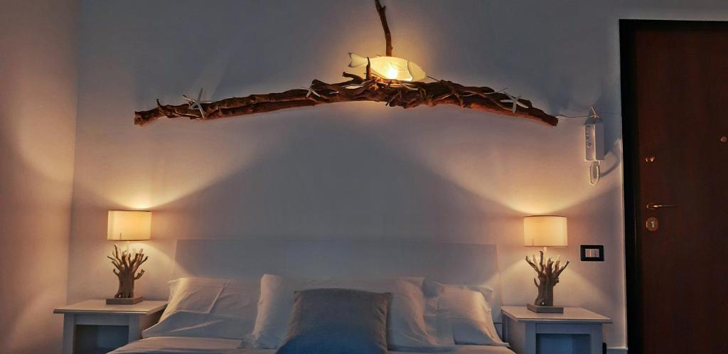 a bedroom with a bed with a branch on the wall at Inn Alta Marea in Salerno