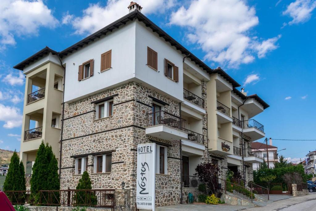 an apartment building with a sign in front of it at Hotel Nostos in Kastoria