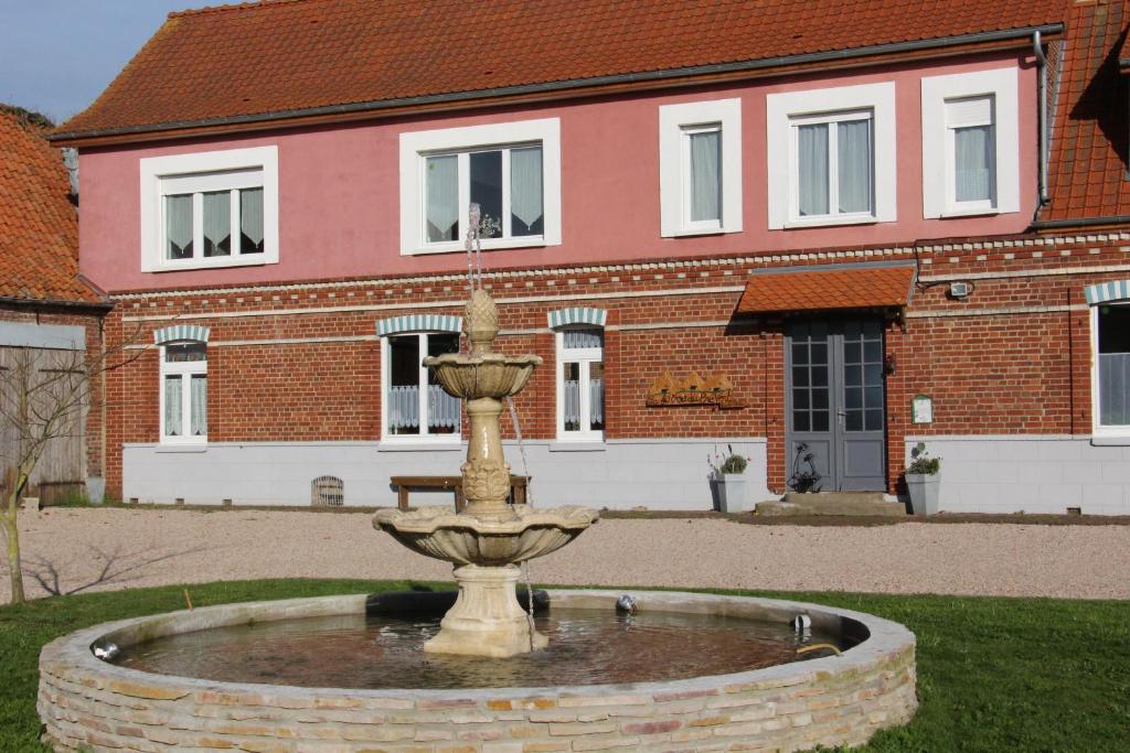 a fountain in front of a brick building at Ferme Du Pre Vert - Chambres d'hôtes B&B in Nort-Leulinghem