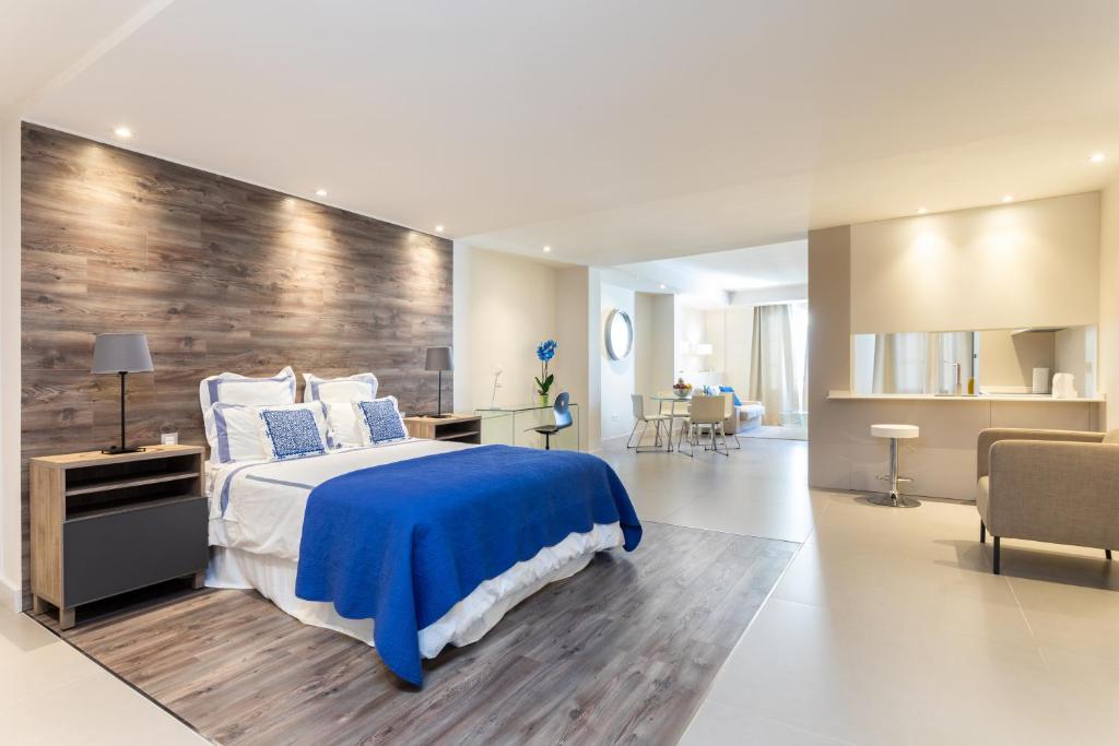 ein Schlafzimmer mit einem Bett und einer Holzwand in der Unterkunft Rooms & Suites Loft 2H Deluxe Edition Arrecife in Arrecife