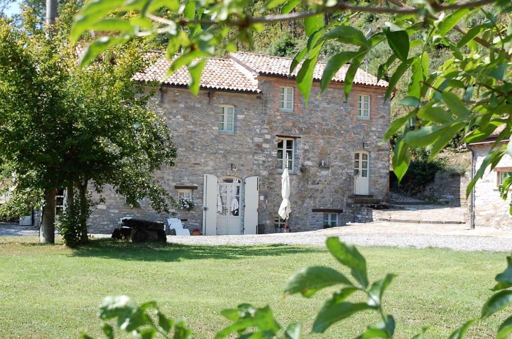 バルディにあるB&B Il Pozzo e la Macinaの庭の白い扉付きの大きな石造りの家