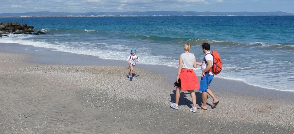 a group of three people walking on the beach at Studio-Pomorie in Pomorie