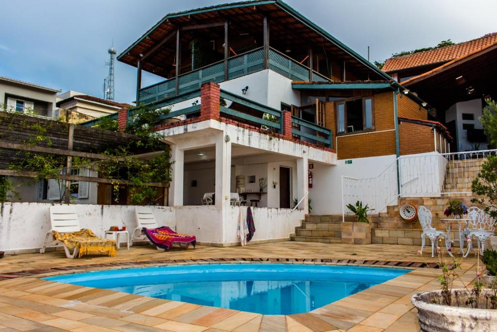 a house with a swimming pool in front of it at Pousada Paraiso do Alto in Paraisópolis