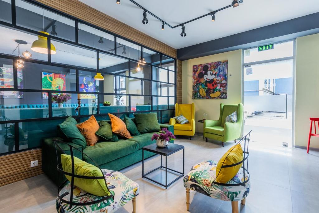 a living room with a green couch and two chairs at Boutique Hotel MOJO in Tbilisi City