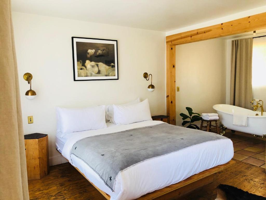 Schlafzimmer mit einem Bett, einer Badewanne und einem Waschbecken in der Unterkunft Alamo Motel in Los Alamos
