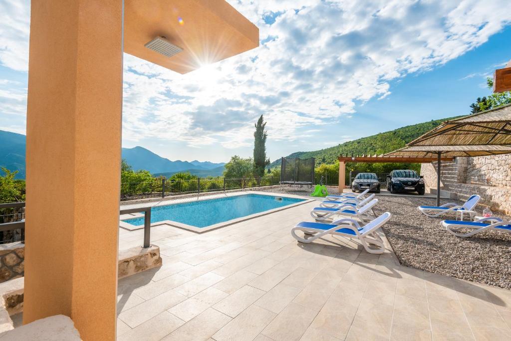 a villa with a swimming pool and lounge chairs at Villa Danica in Vid