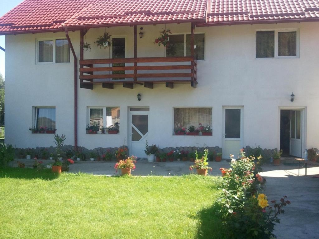 a large white house with a red roof at Pensiunea Ilaria in Bran