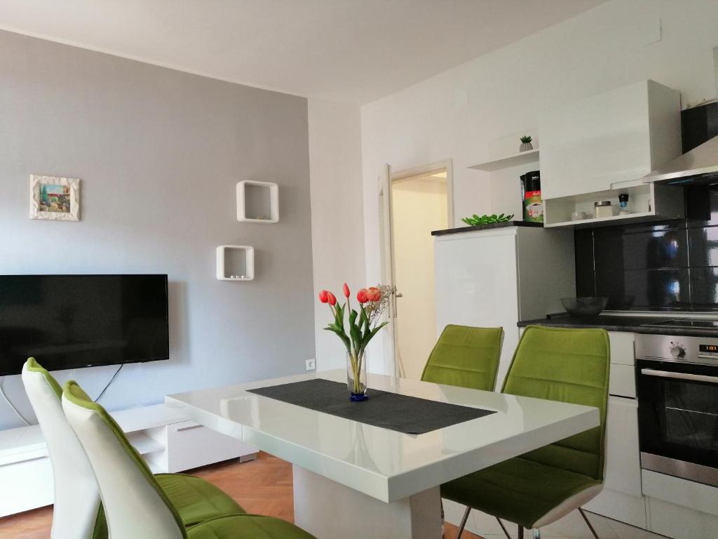 a living room with a white table and green chairs at Apartment Antea in Šibenik