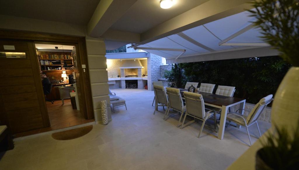 诺瓦利娅Rooms Villa Ropuš的天井配有桌椅和遮阳伞