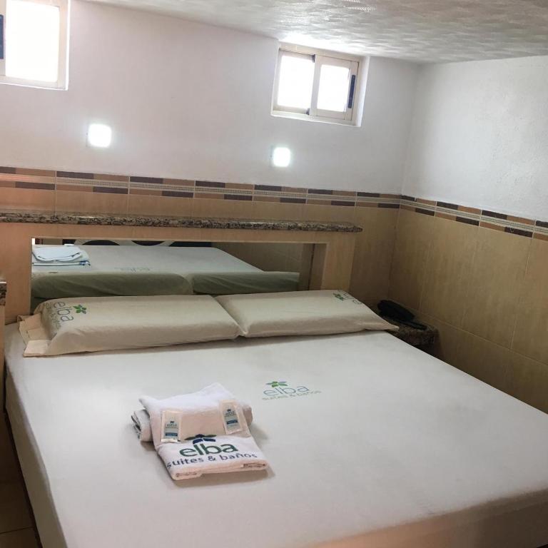 - une chambre avec 2 lits dans une pièce avec fenêtres dans l'établissement Hotel & suites elba, à Toluca