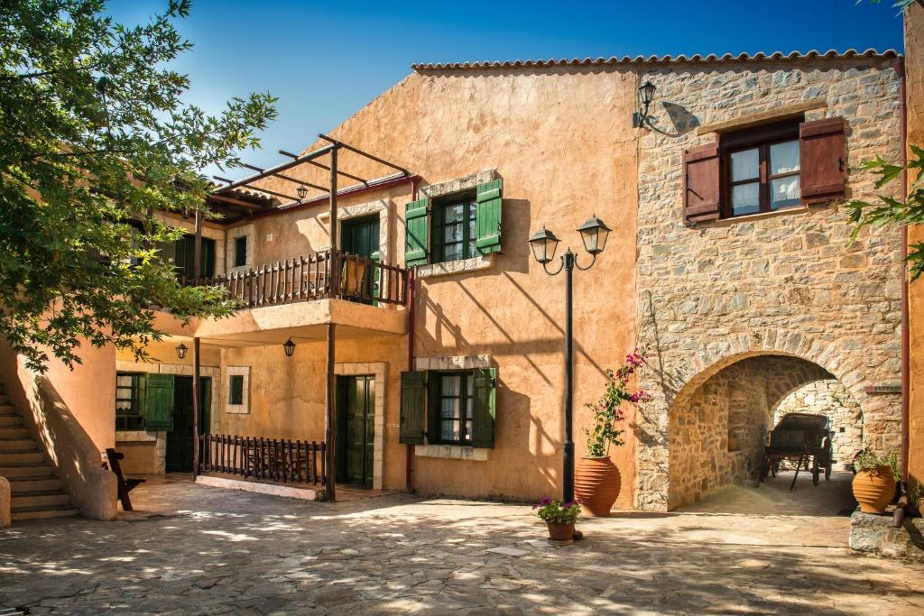 een oud stenen gebouw met een balkon en een binnenplaats bij Enagron Ecotourism Village in Axós