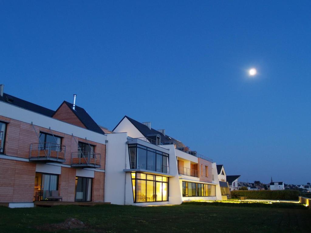un edificio de apartamentos con la luna en el cielo en Logis Le Château de Sable, en Porspoder
