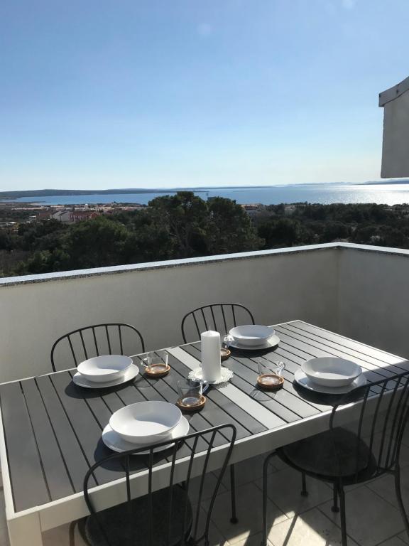 un tavolo su un balcone con vista sull'oceano di Apartment Noa Zrće Beach a Skunca