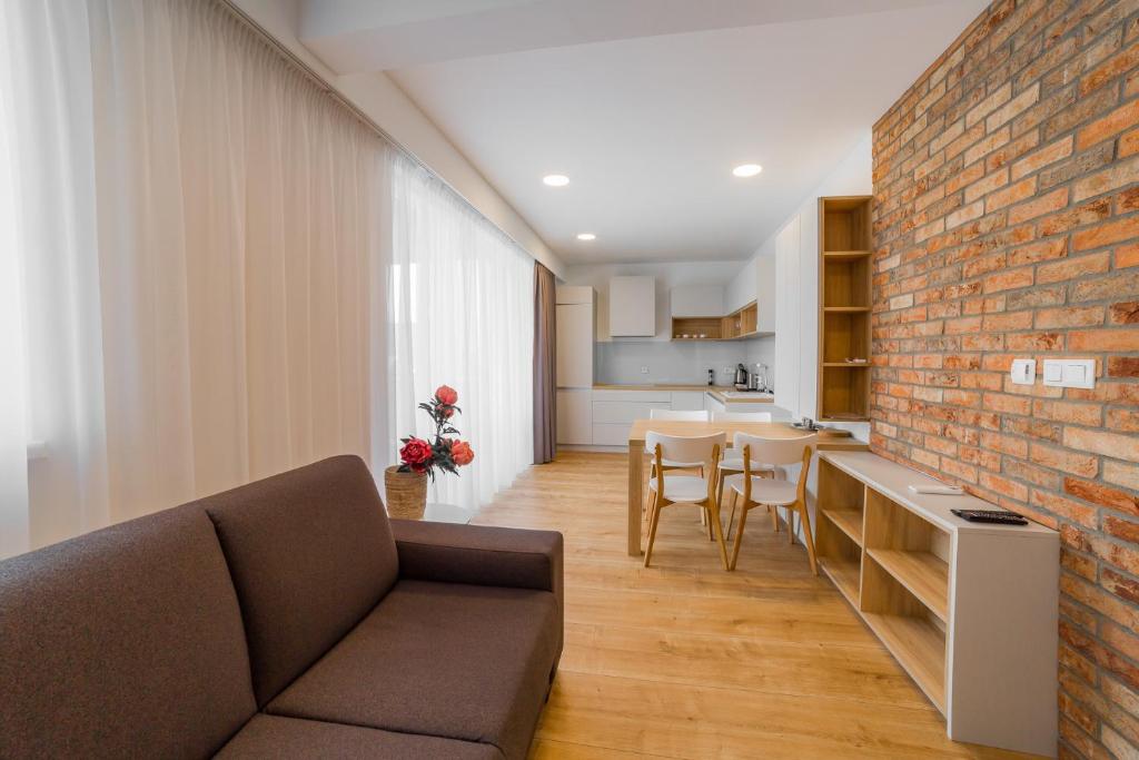 a living room with a couch and a brick wall at Apartment Dolfi, Senec in Senec