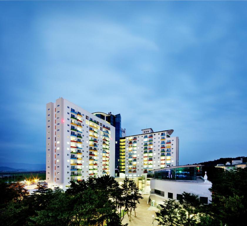 a tall building with lights on in a city at Hanwha Resort Daecheon Paros in Boryeong