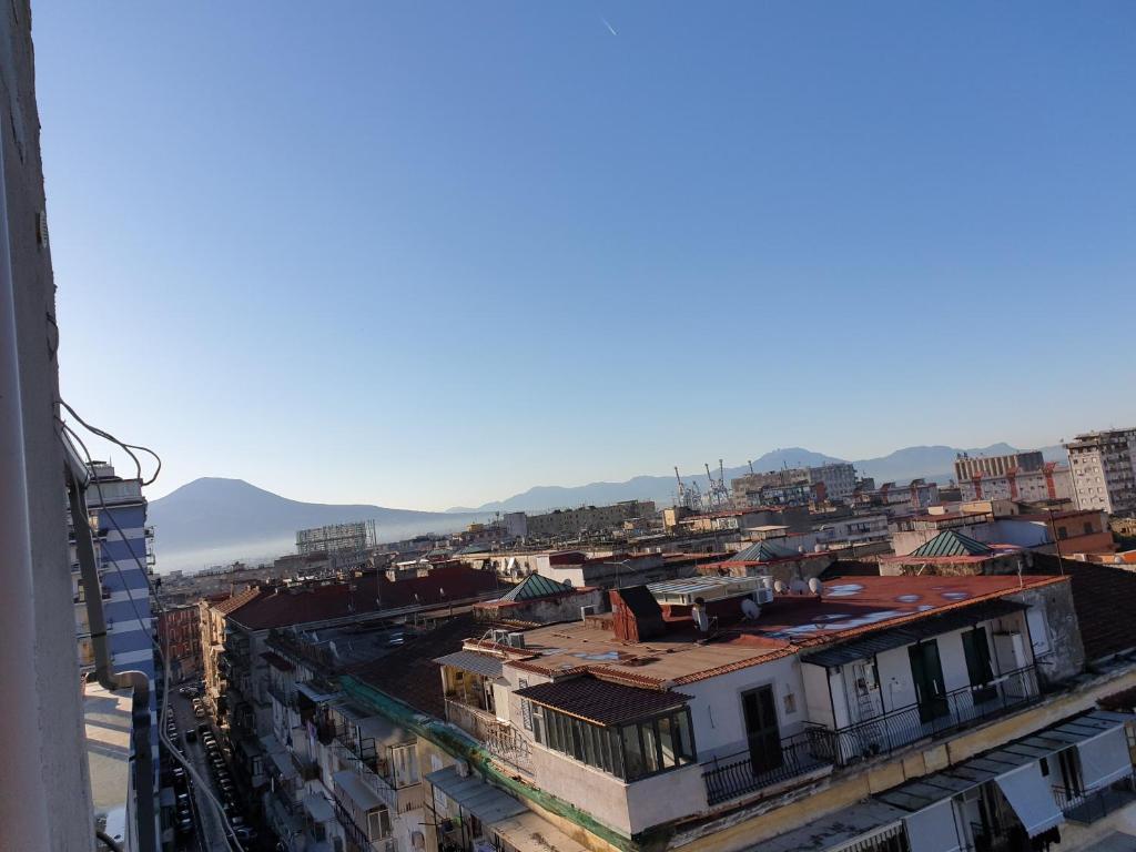 a city with buildings and mountains in the background at fitta camere portanolana in Naples