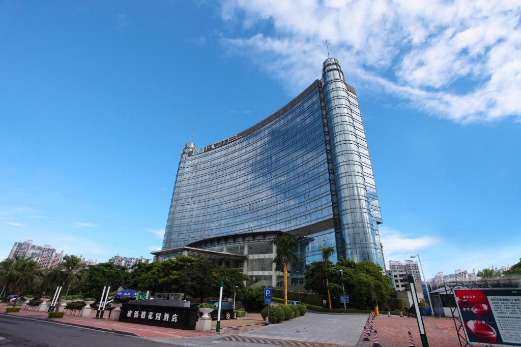 wysoki szklany budynek przy ulicy miejskiej w obiekcie KB Hotel Qingyuan w mieście Qingyuan