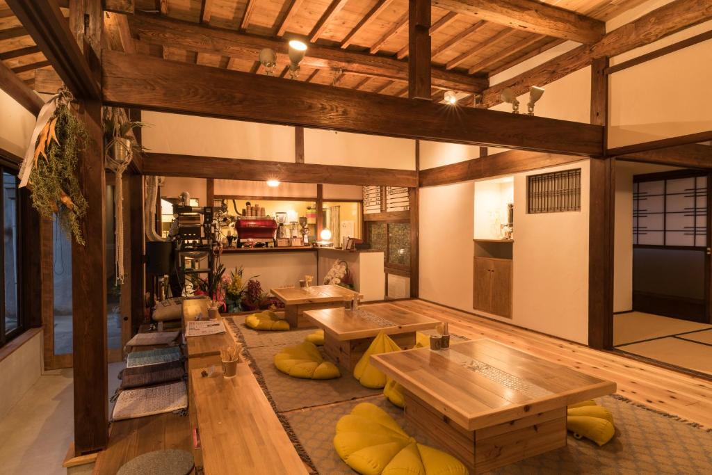 una grande stanza con tavoli in legno e una cucina di 猿とモルターレ a Kishiwada