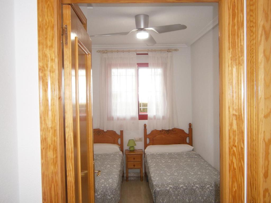 1 Schlafzimmer mit 2 Betten und einem Deckenventilator in der Unterkunft Apartamento Frente Al Mar in Villajoyosa