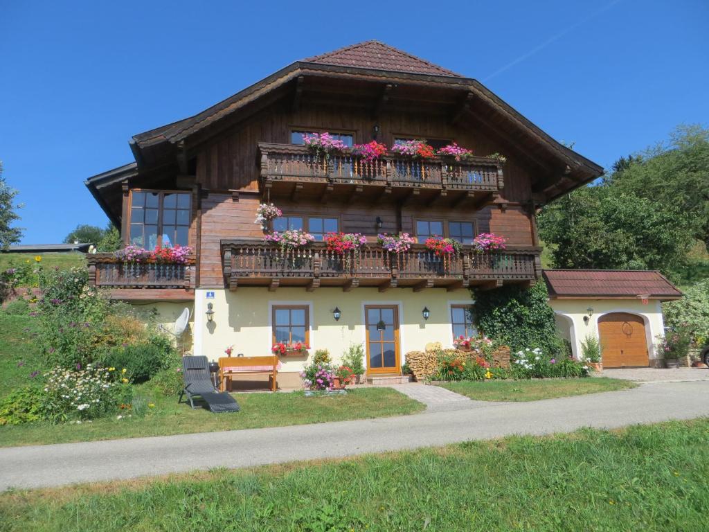 a house with flower boxes on the balcony at Ferienwohnung Brigitte Perner in Nussdorf am Attersee