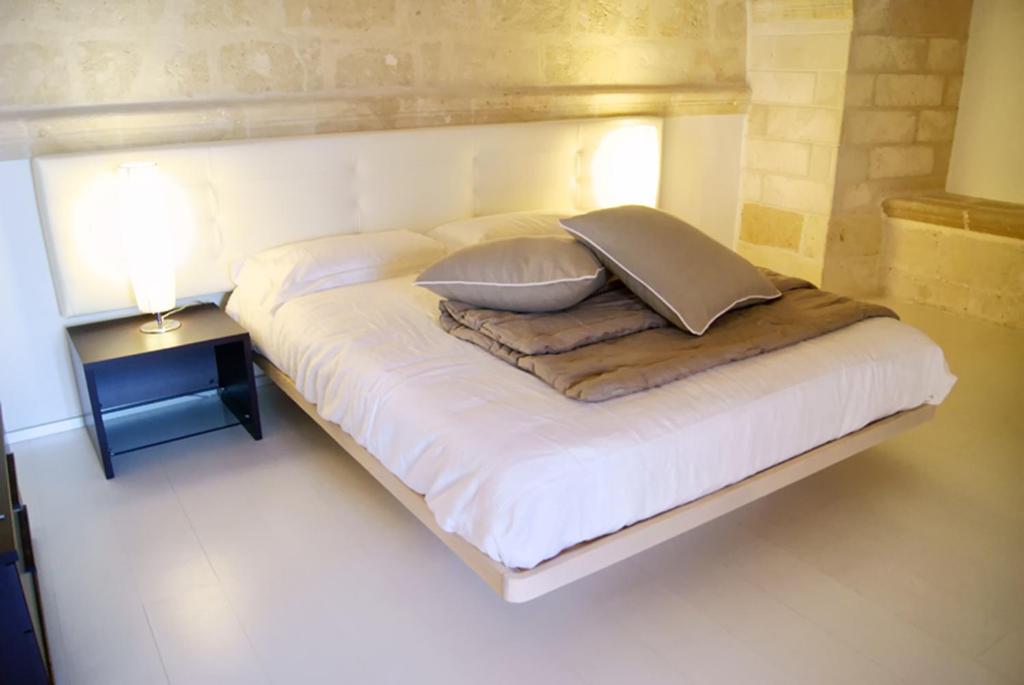een wit bed met twee kussens erop bij B & B Sotto la Volta in Massafra