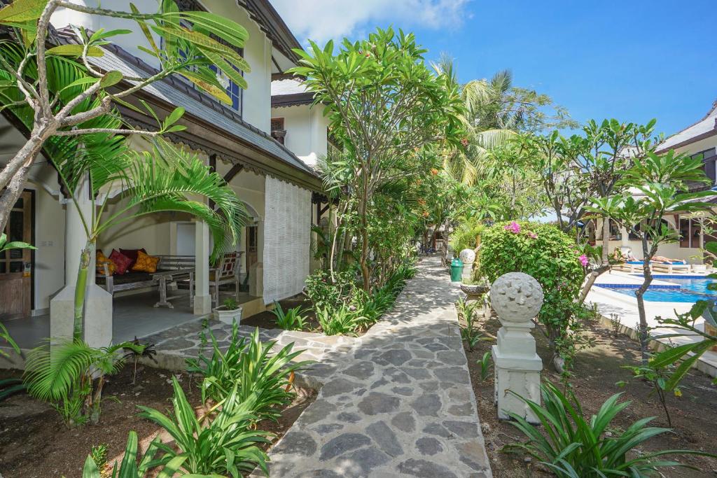 a house with a garden and a swimming pool at Martas Hotel in Gili Trawangan