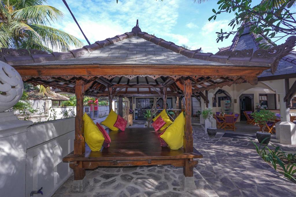 a wooden gazebo with colorful pillows on it at Martas Hotel in Gili Trawangan