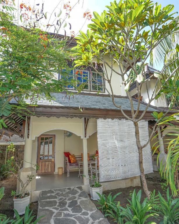a house with a tree in front of it at Martas Hotel in Gili Trawangan