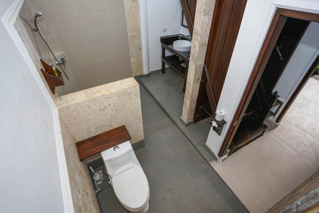 a small bathroom with a toilet and a sink at Martas Hotel in Gili Trawangan