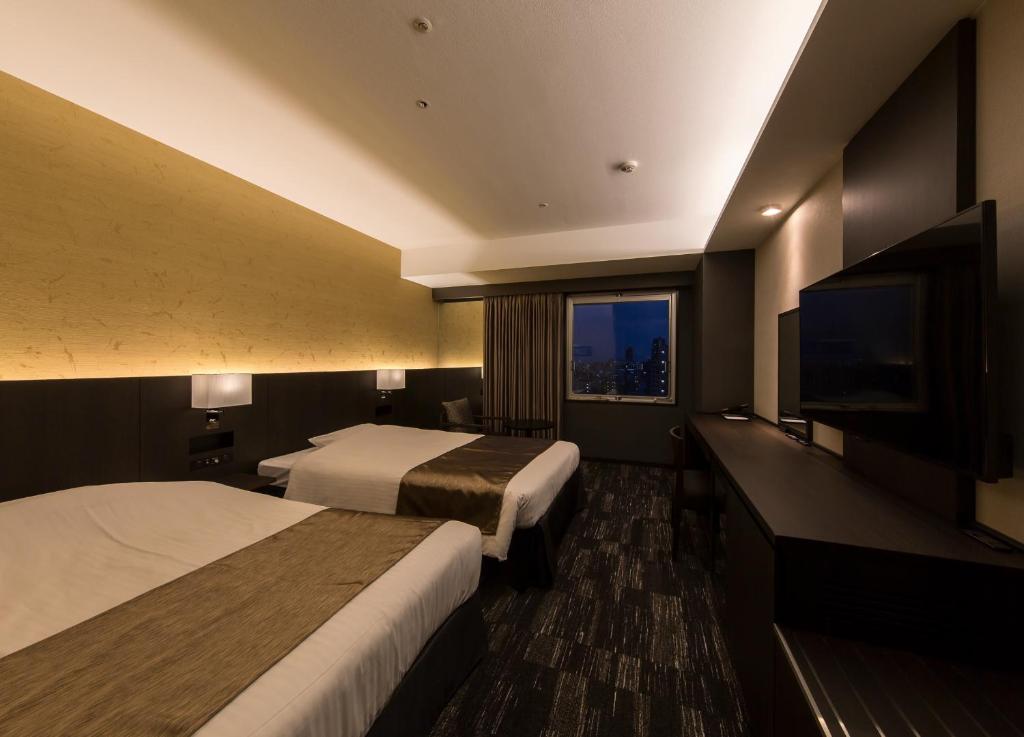 Кровать или кровати в номере KKR Hotel Osaka